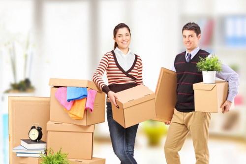 Professional movers carrying furniture through a narrow staircase in Belgium