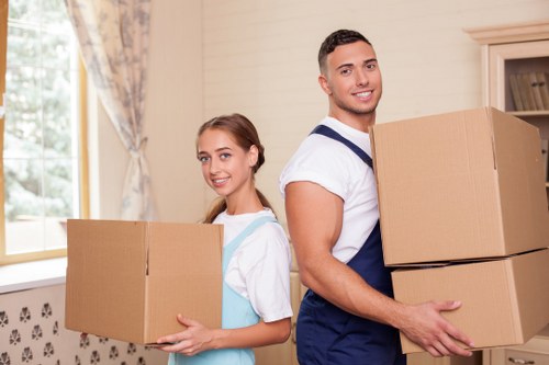 Moving truck and movers unloading household items at a Belgium property
